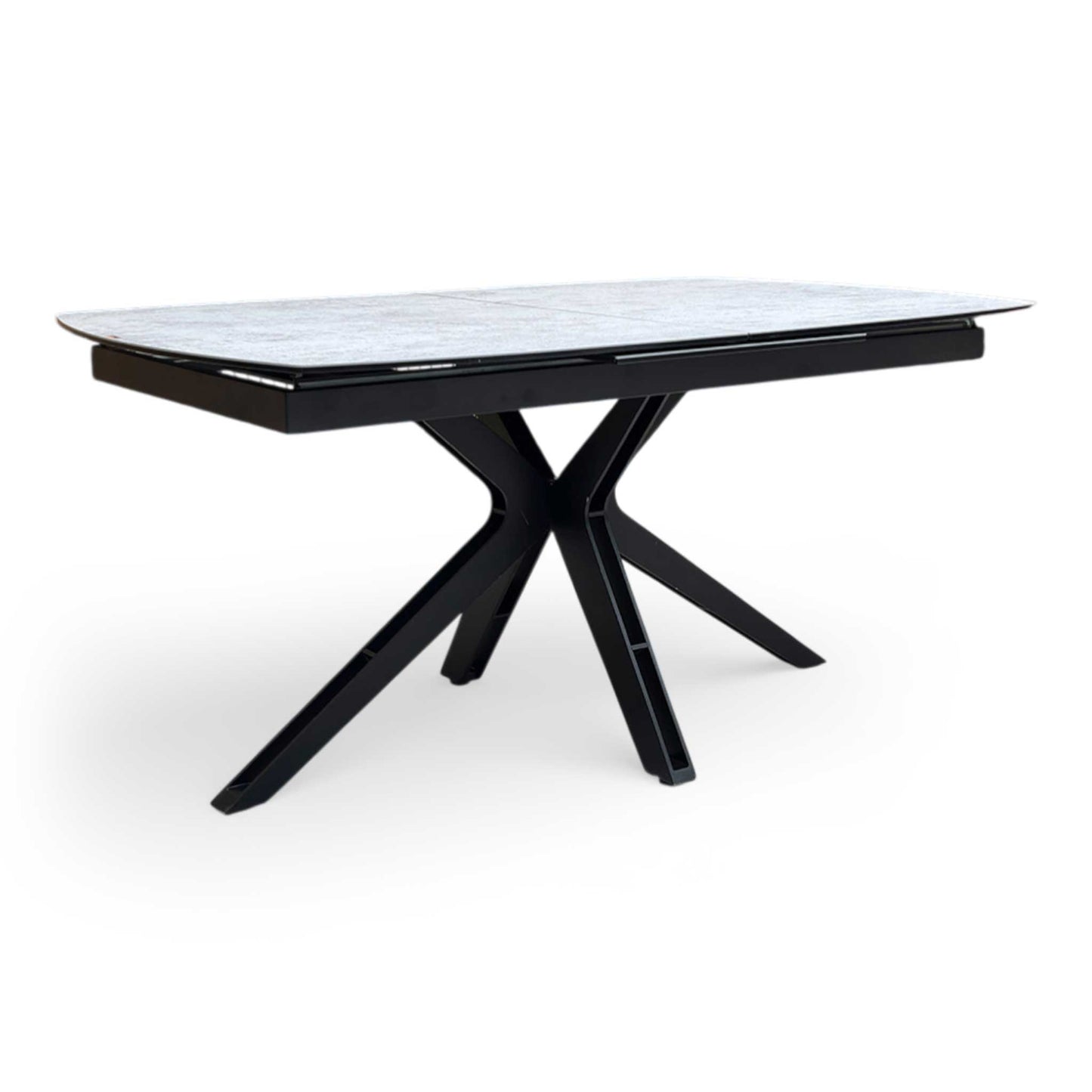Full view of Modern Raul extending dining table featuring a silver ceramic boat-shaped top and black star-shaped metal legs.