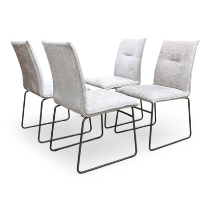 Full view of Set of four Connubia Maya dining chairs featuring sand-colored fabric upholstery and contemporary lava-finish metal ski-style legs.