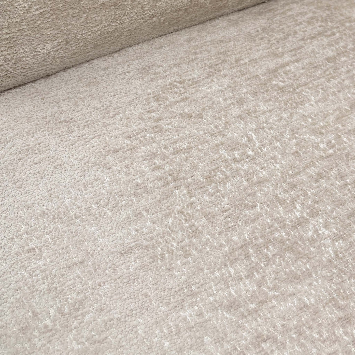 Close-up of the sand-colored fabric, showcasing the pinched seam tailoring along the edges and the central horizontal backrest groove.