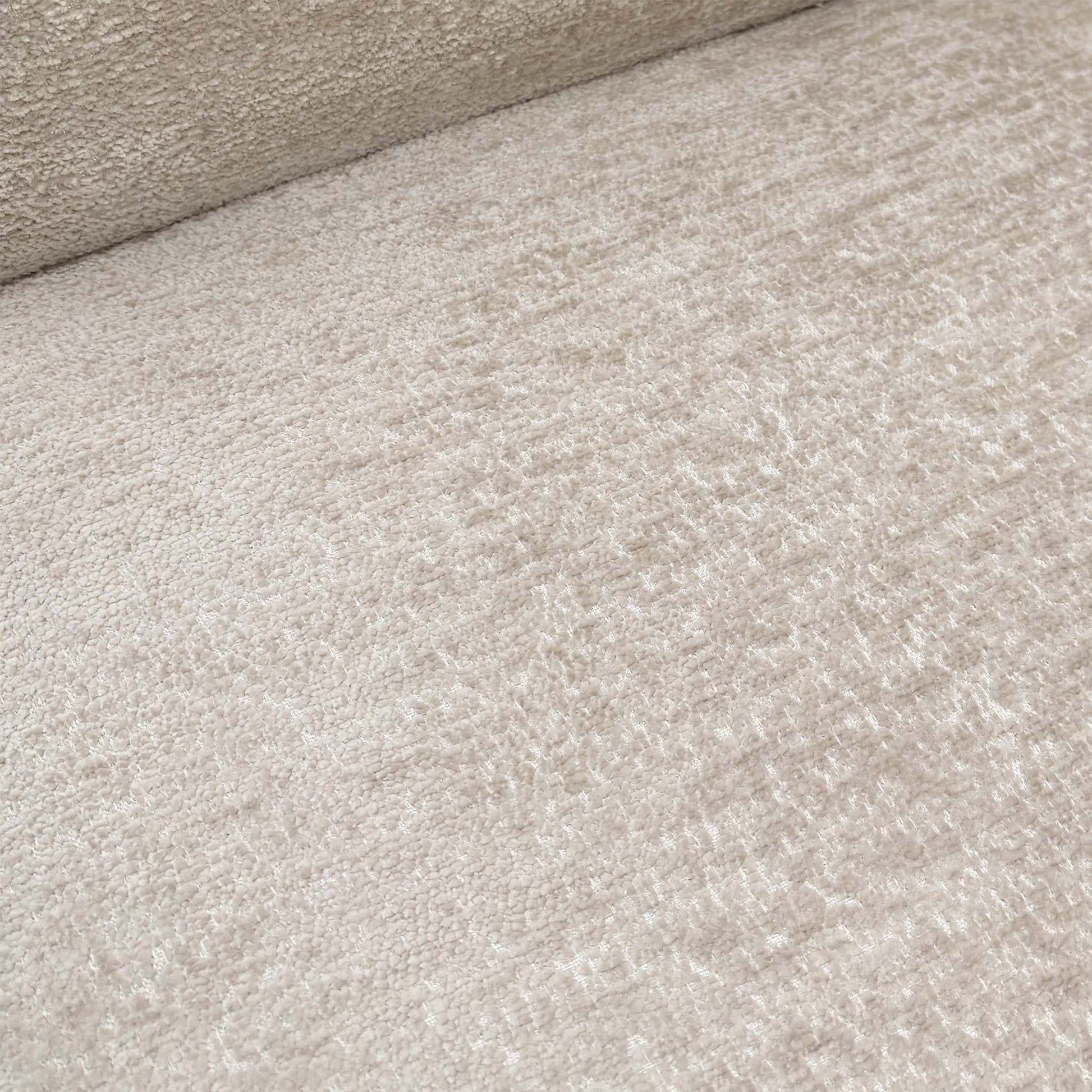 Close-up of the sand-colored fabric, showcasing the pinched seam tailoring along the edges and the central horizontal backrest groove.