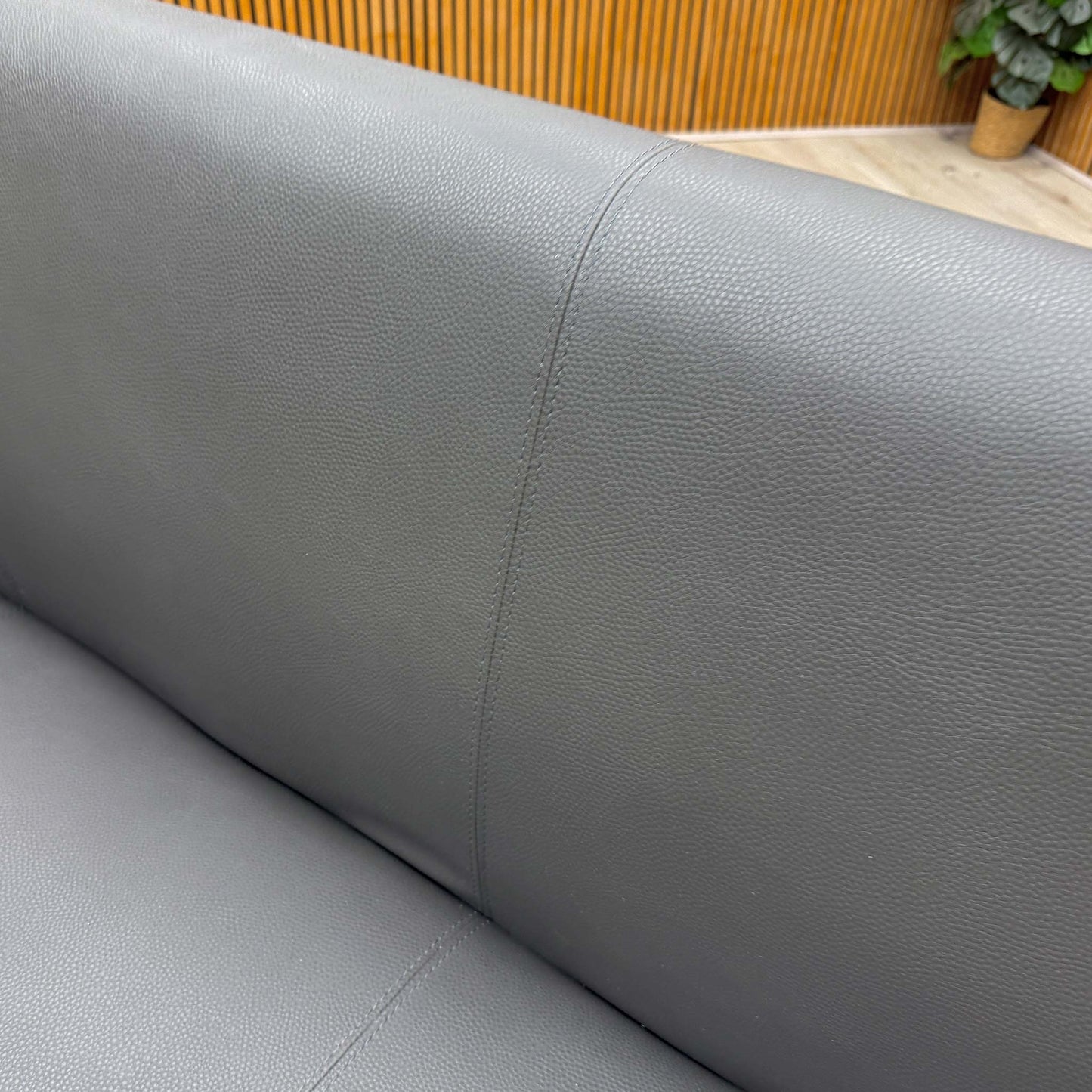 Close-up of the stain-resistant grey faux leather upholstery, emphasizing its soft and practical finish.