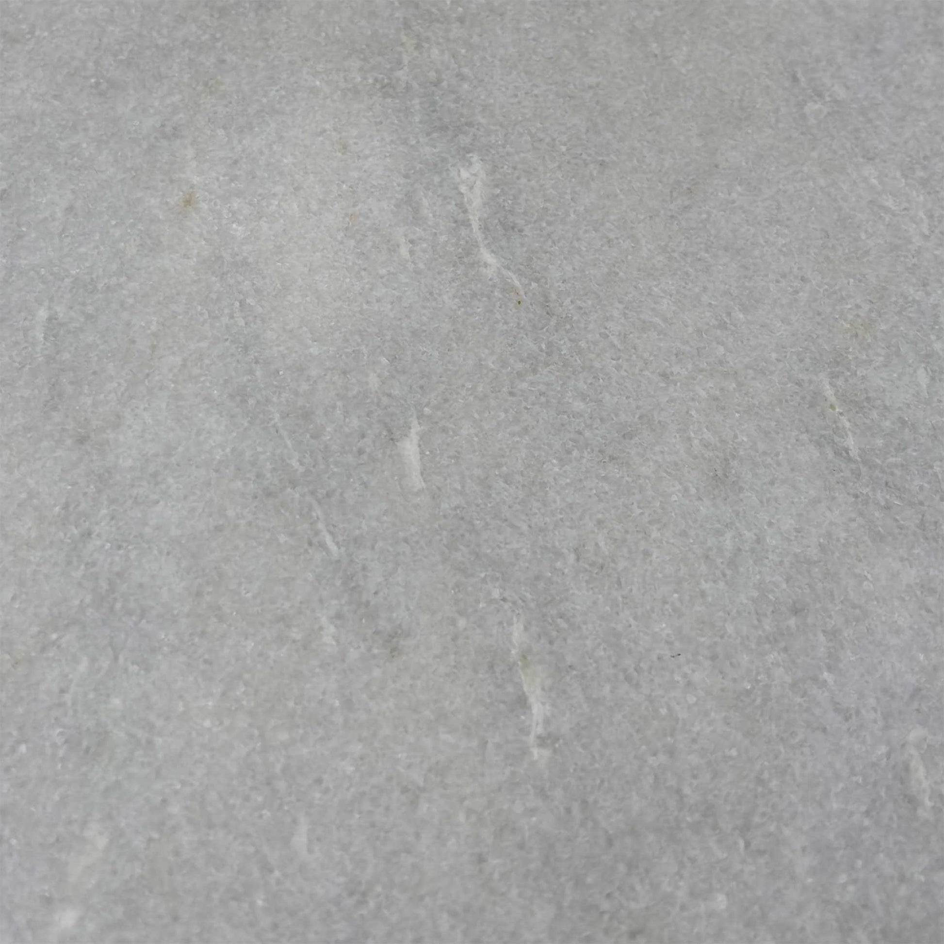 Close-up of the white ceramic surface, highlighting the subtle grey marble veining and the durable, easy-to-clean matte finish.