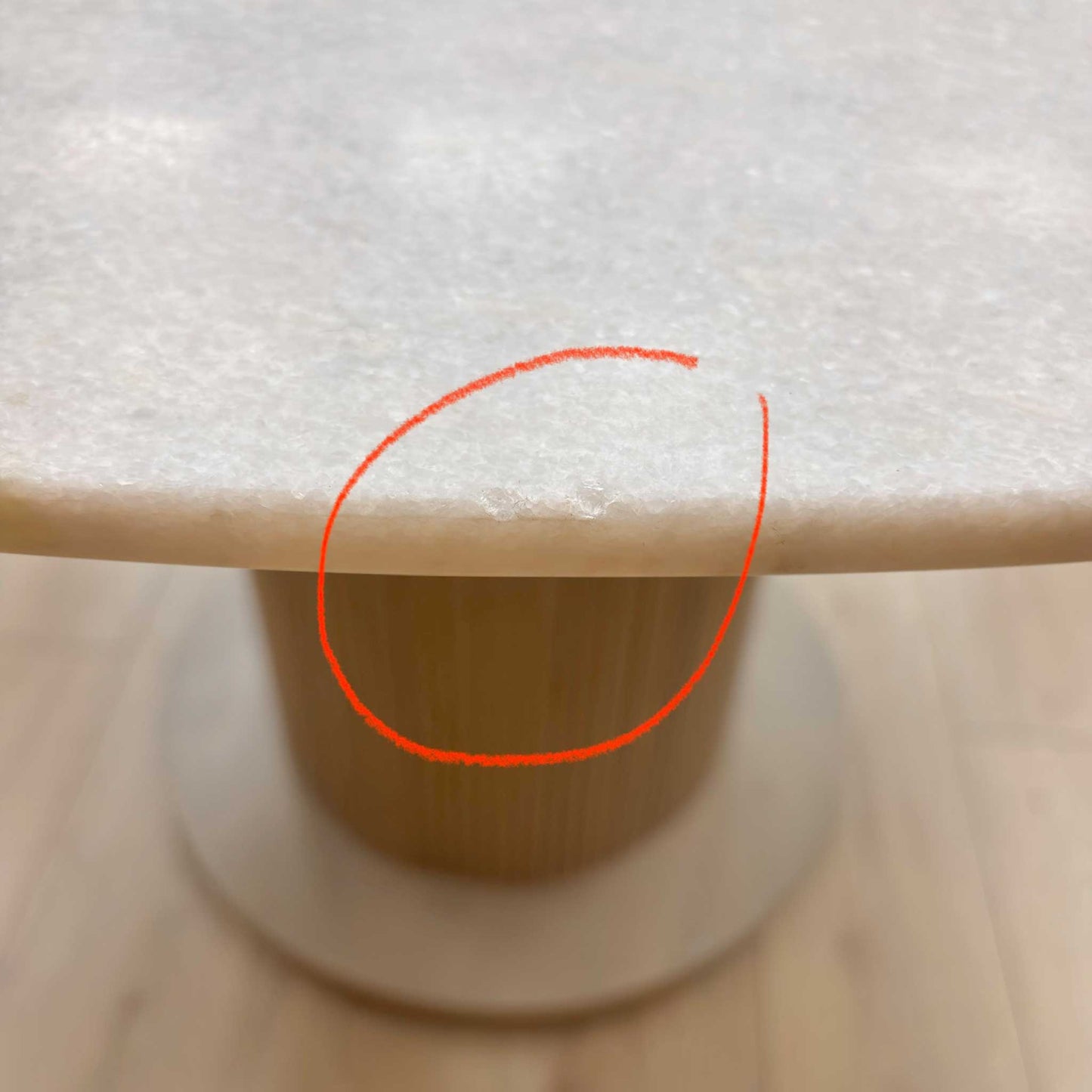 Close-up of the white ceramic surface, highlighting the damage.