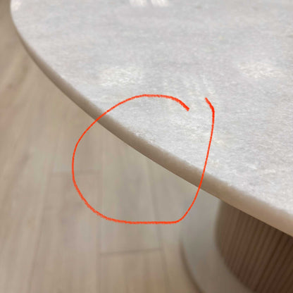 Close-up of the white ceramic surface, highlighting the damage.