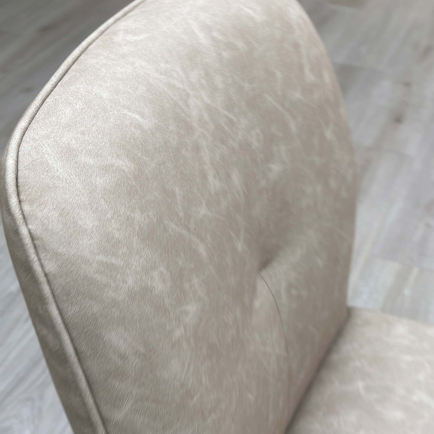 Close up view of the soft stone-colored neutral fabric upholstery on the Perla dining chair.
