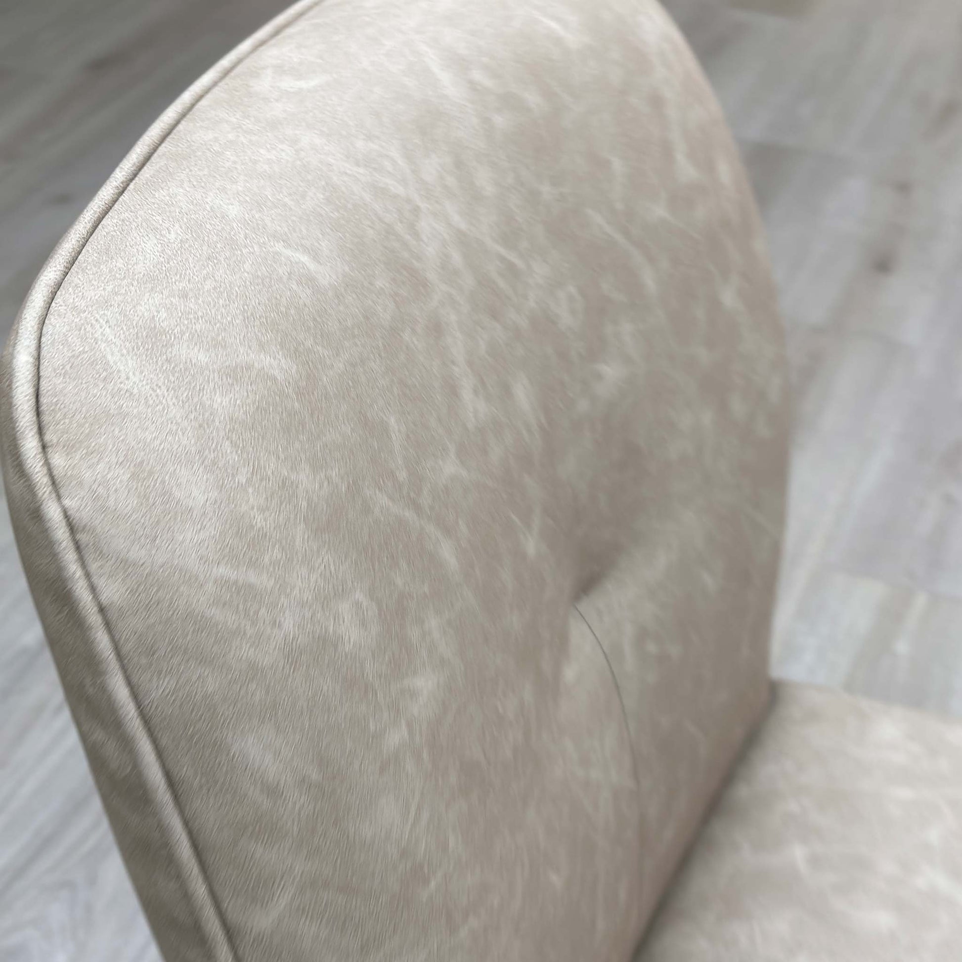 Close up view of the soft stone-colored neutral fabric upholstery on the Perla dining chair.