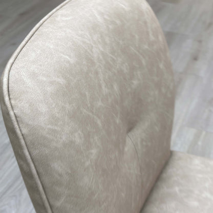 Close up view of the soft stone-colored neutral fabric upholstery on the Perla dining chair.