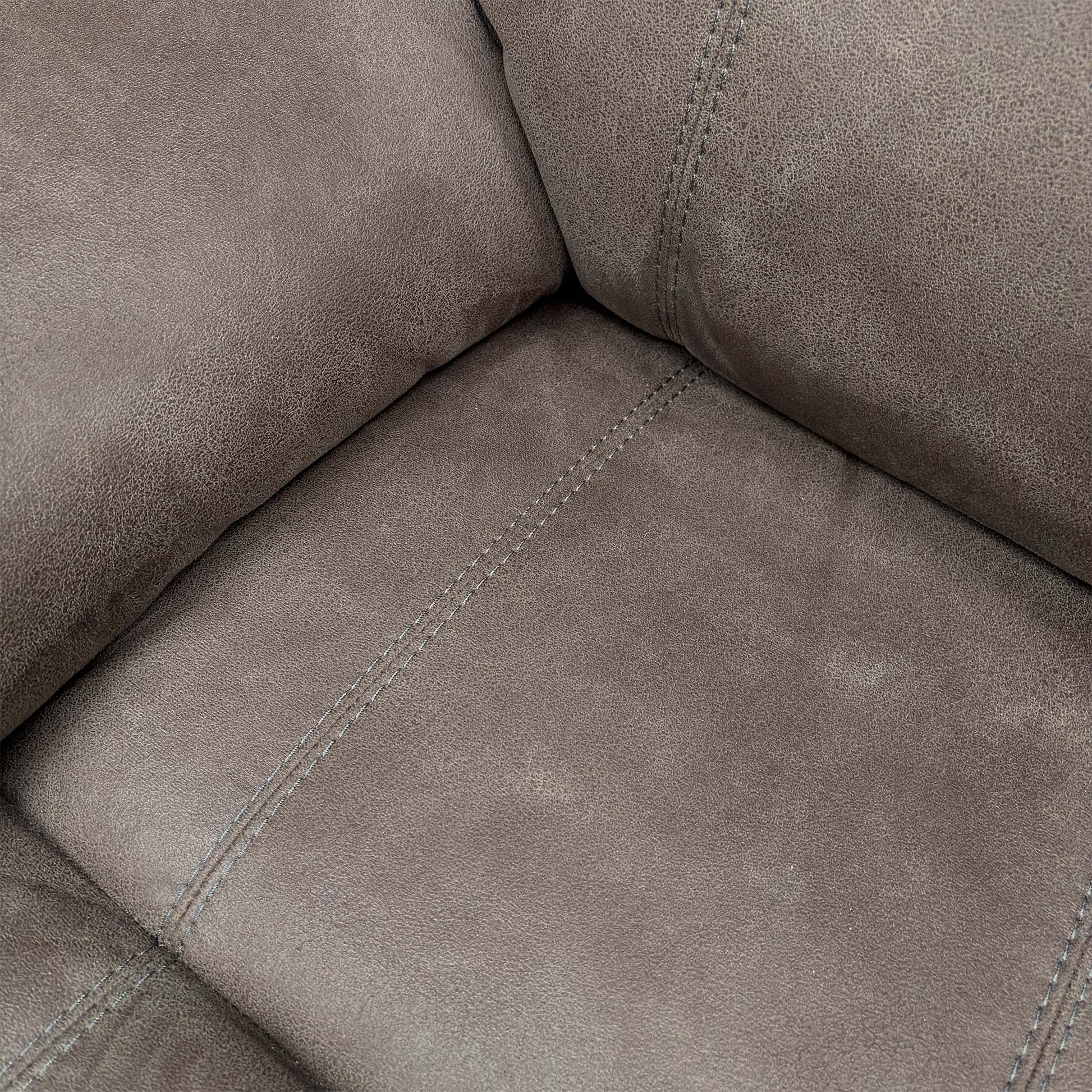 Close-up of the grey suede fabric texture, illustrating the soft-touch finish and high-quality tailoring of the upholstery.