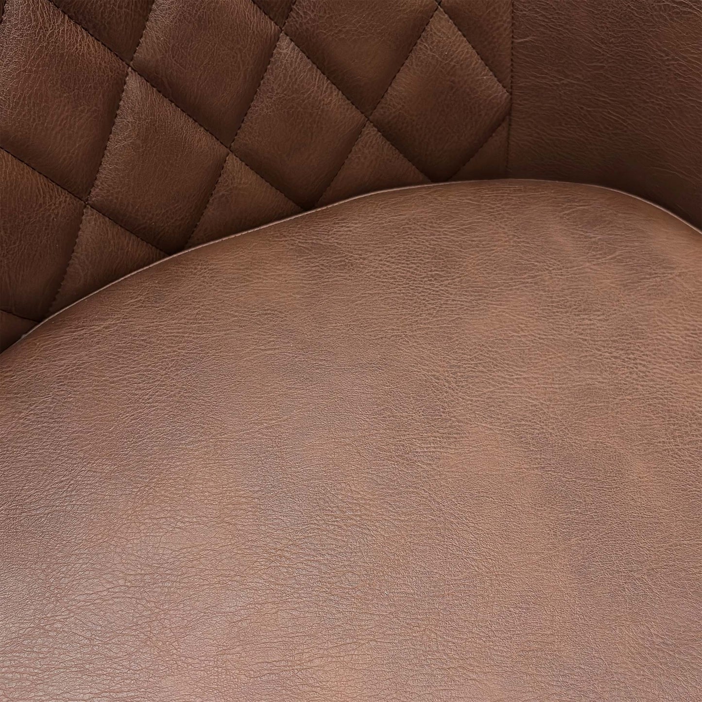 Close-up of the tan brown faux leather upholstery, highlighting the detailed quilting and durable material.
