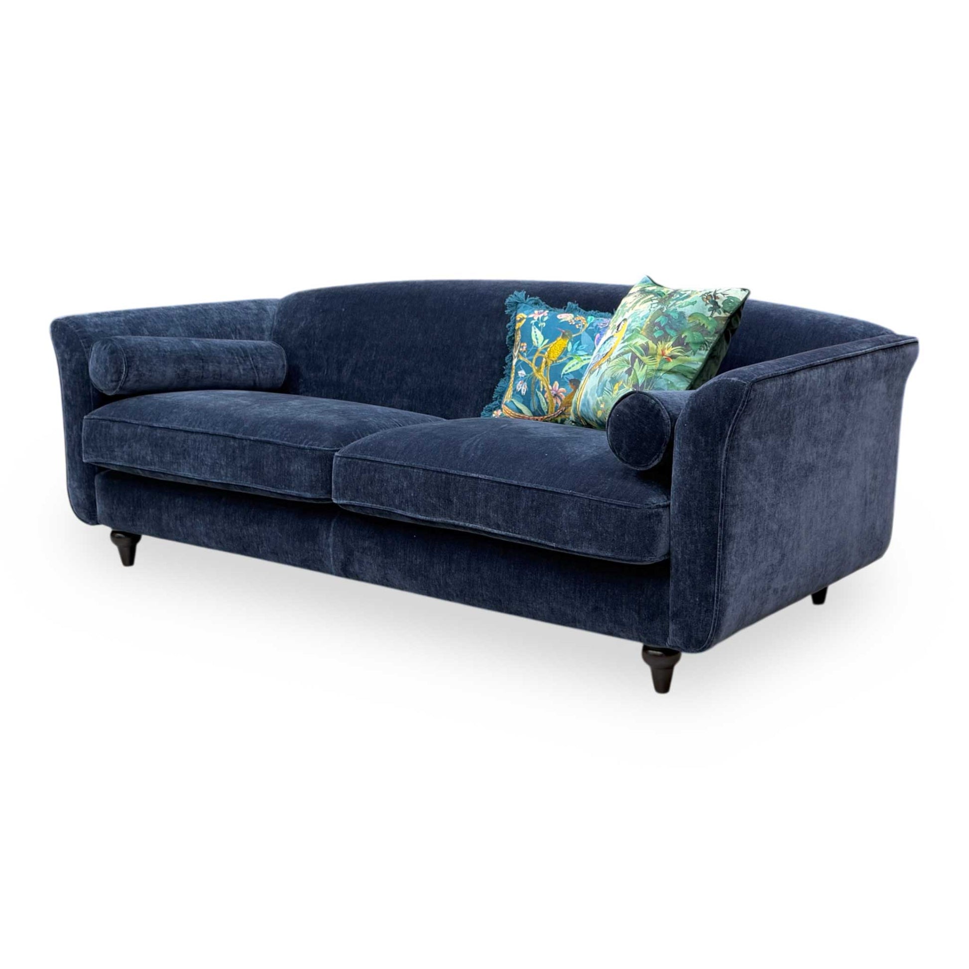 Side profile of the Dame sofa, highlighting the clean lines and included cylindrical bolster cushions.