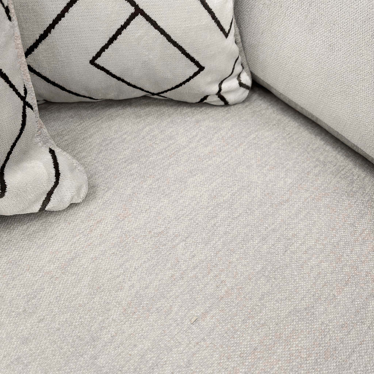 Close-up of the truffle Derwent soft weave fabric on the Harvey sofa seat with a geometric scatter cushion