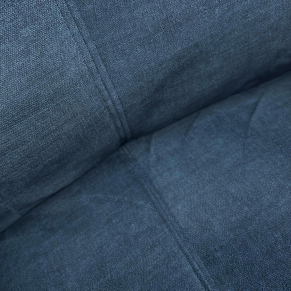 Close-up of the plush Deep Sea Blue velvet upholstery and cushioned backrest.