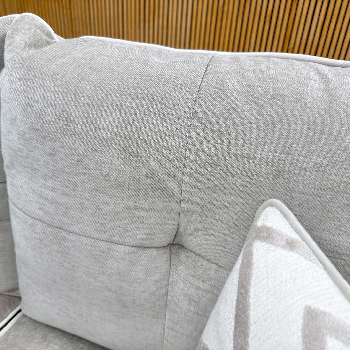 Detailed shot of the high-quality linen fabric texture and reversible fiber-filled back cushions.