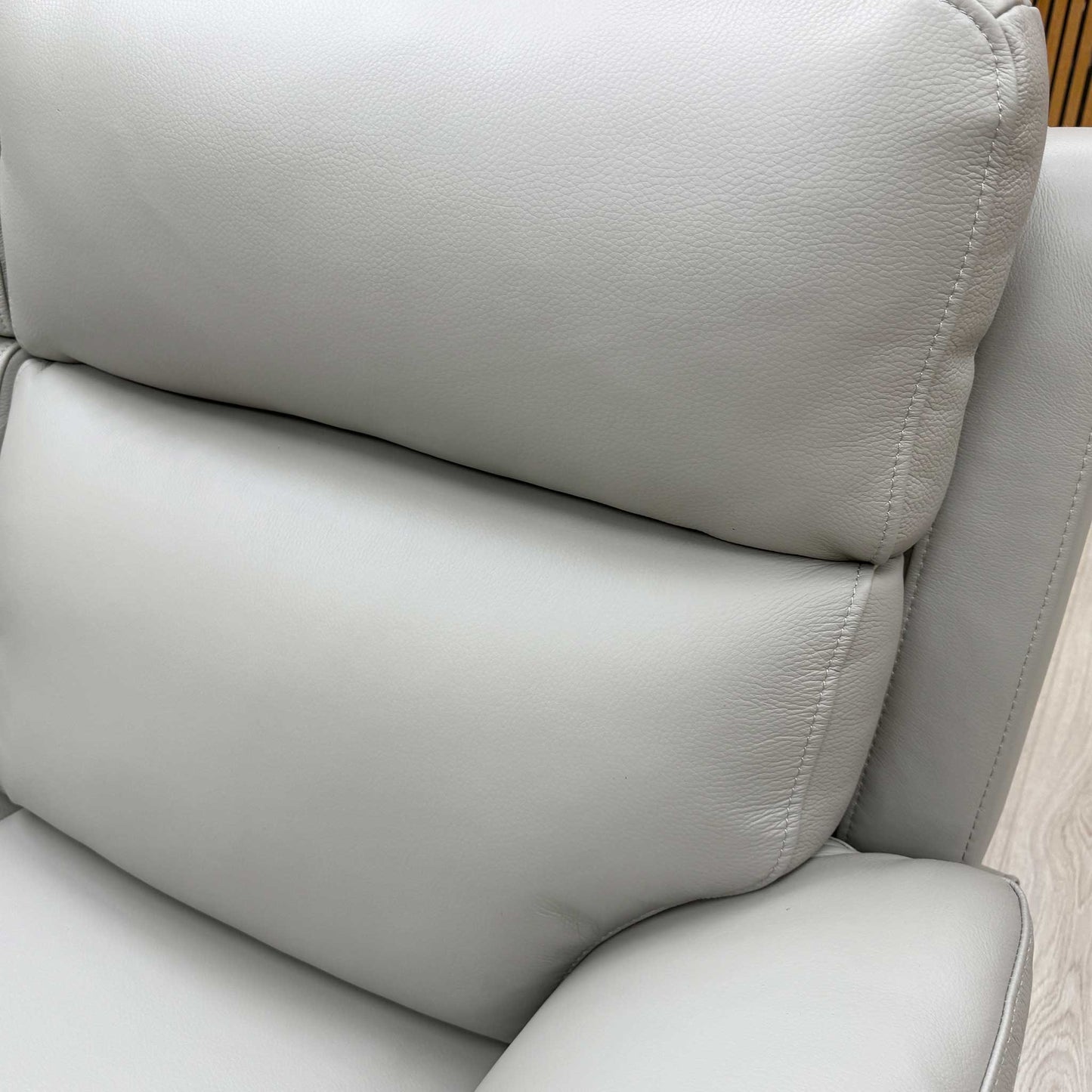 Close-up of the light grey leather upholstery, detailing the stitching and premium finish.