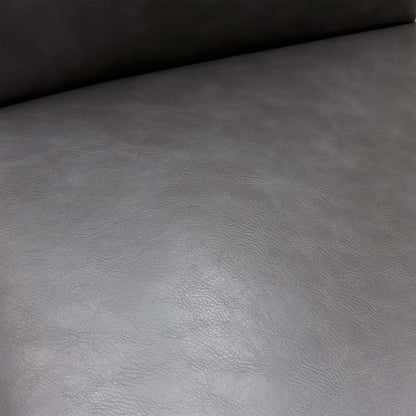 Close-up of the dark grey faux leather upholstery and elegant buttoned finish on the backrest.