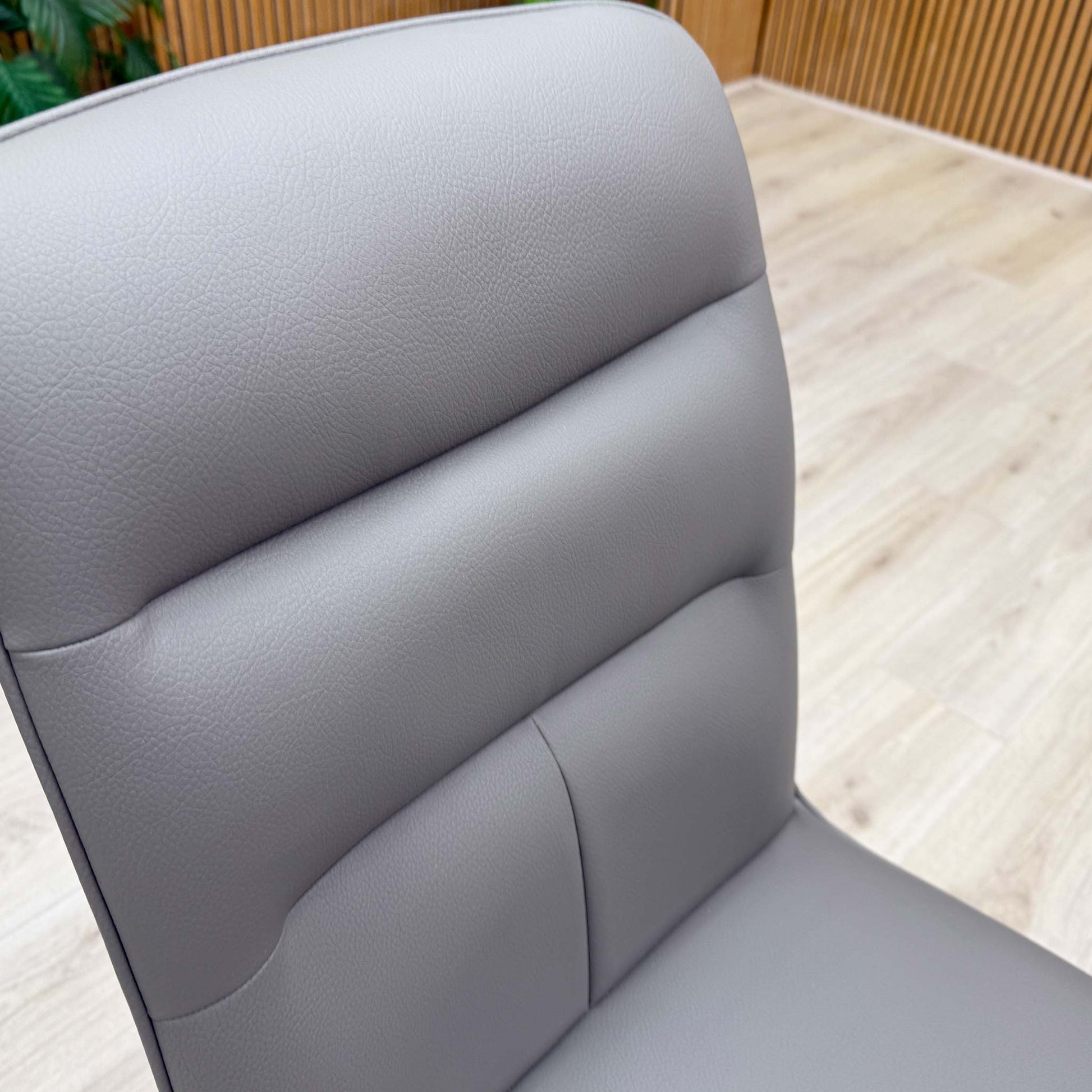Close up of the chair displaying the clean finish of the upholstery and the polished stainless steel frame.
