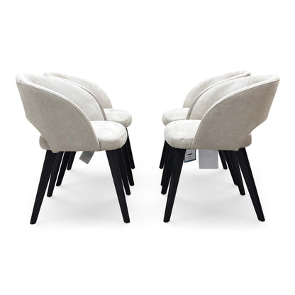 Front-facing view of a Goya dining chair, showcasing the understated glam style, comfortable low-back silhouette, and dense foam seat cushioning.