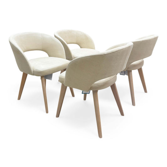 Full view of the Goya dining chair featuring a curved low-back silhouette in Lizard Cream fabric with dark beech wood legs.