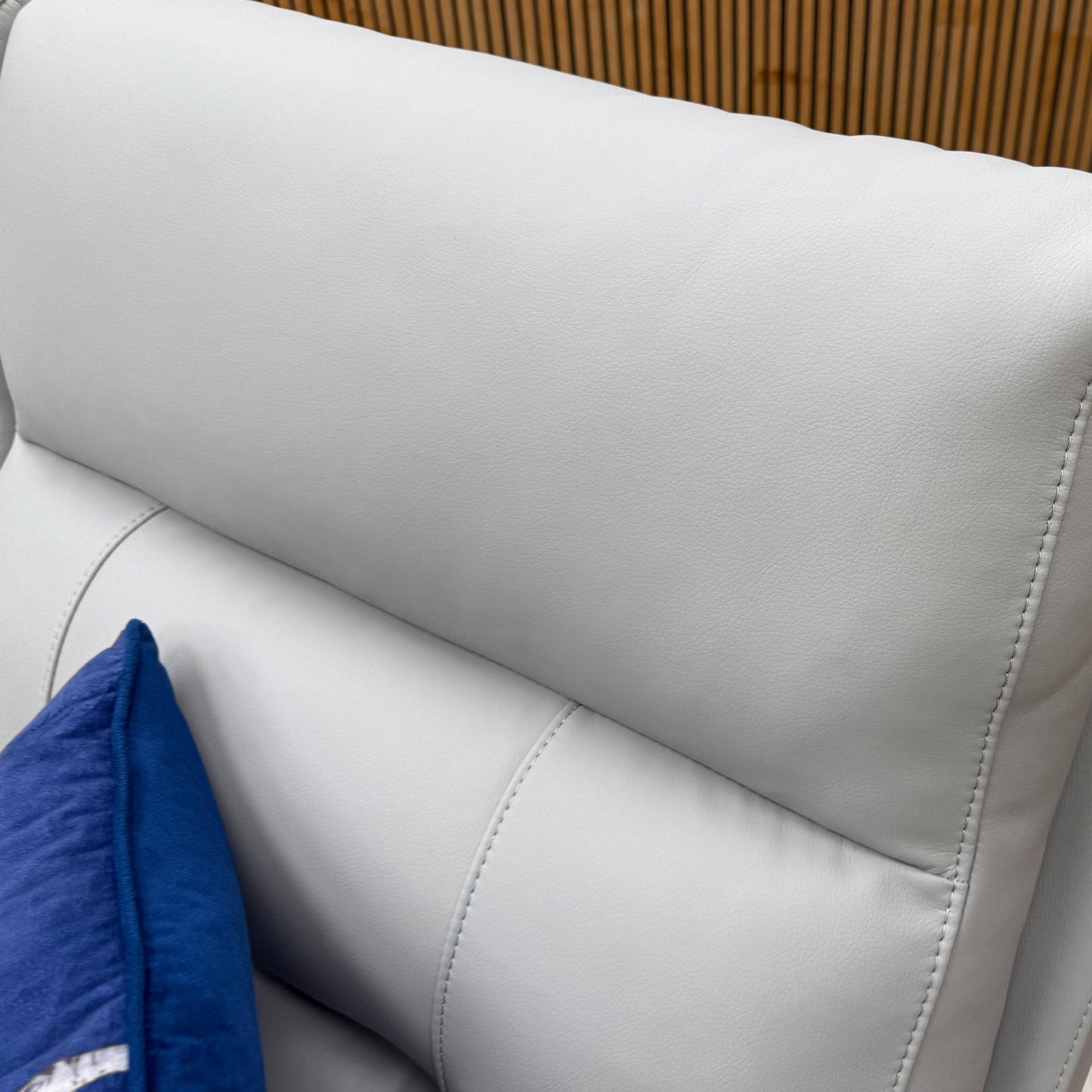 Close-up of the premium light grey leather upholstery on the Sally sofa, highlighting the fine texture and stitching.