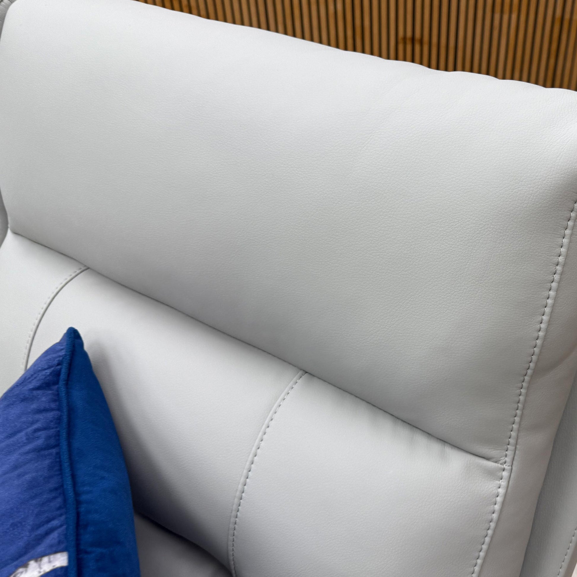 Close-up of the premium light grey leather upholstery on the Sally sofa, highlighting the fine texture and stitching.