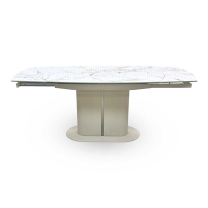 Front view of the Avorio dining table, demonstrating the smooth, effortless swivel action of the extension mechanism and the premium tactile feel of the ceramic top.
