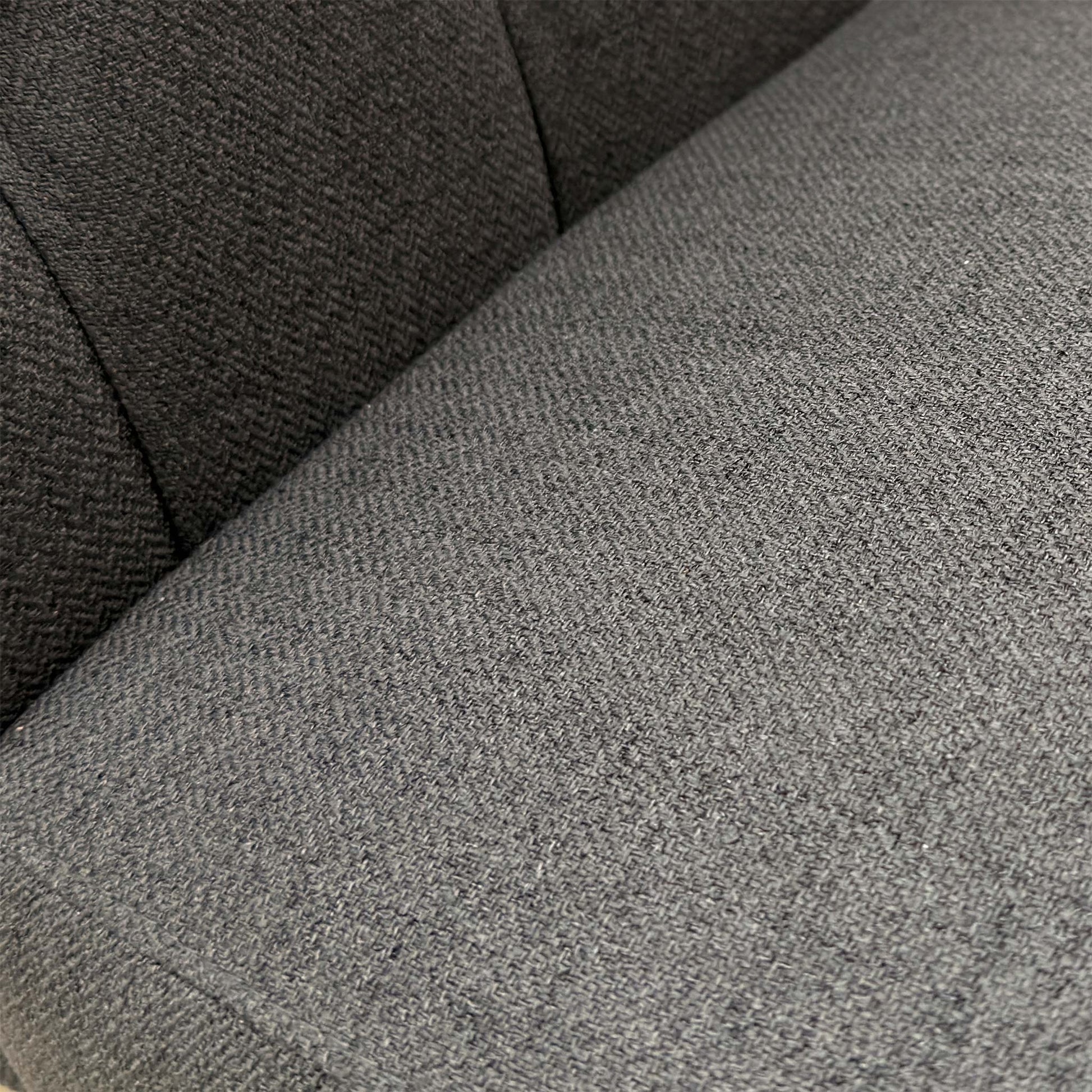 Close-up of the anthracite grey fabric and button detailing on the high-back chair.