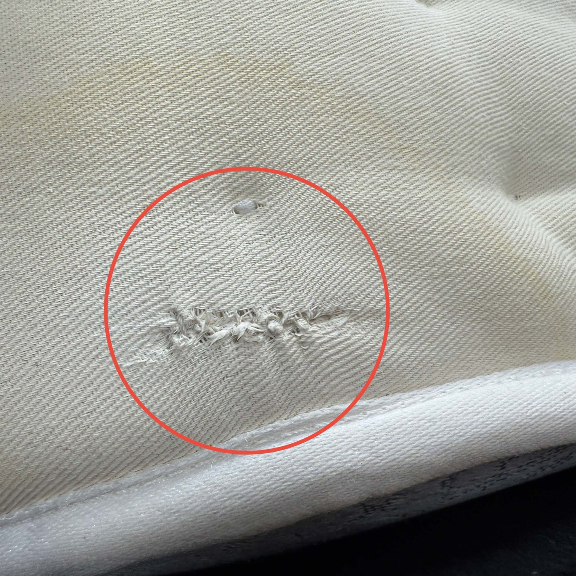 Close-up of a small area of damage on the mattress surface, as noted in the clearance product description.