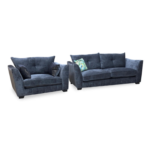 Full view of the ‘Allure’ Coco Indigo woven fabric furniture set, featuring a 3-seater classic back sofa and a matching snuggler chair with dark wood feet.