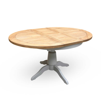 Full view of the Joseph round extending dining table in medium oak, showcasing its warm wood tones, classic circular shape, and central pedestal base.