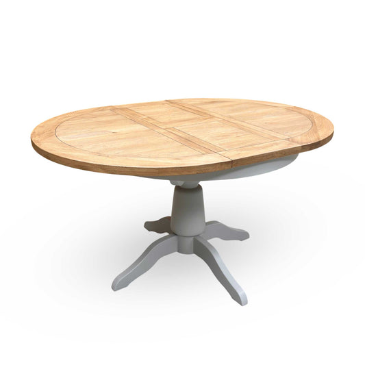 Full view of the Joseph round extending dining table in medium oak, showcasing its warm wood tones, classic circular shape, and central pedestal base.