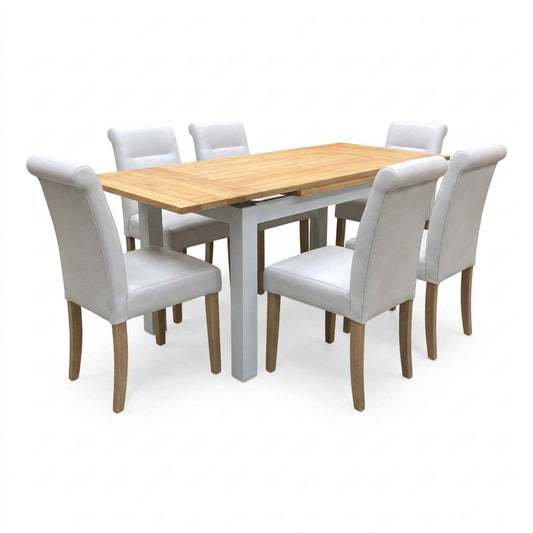Lewis solid oak dining table set, angled view from the left with the draw leaves extended and six light grey chairs
