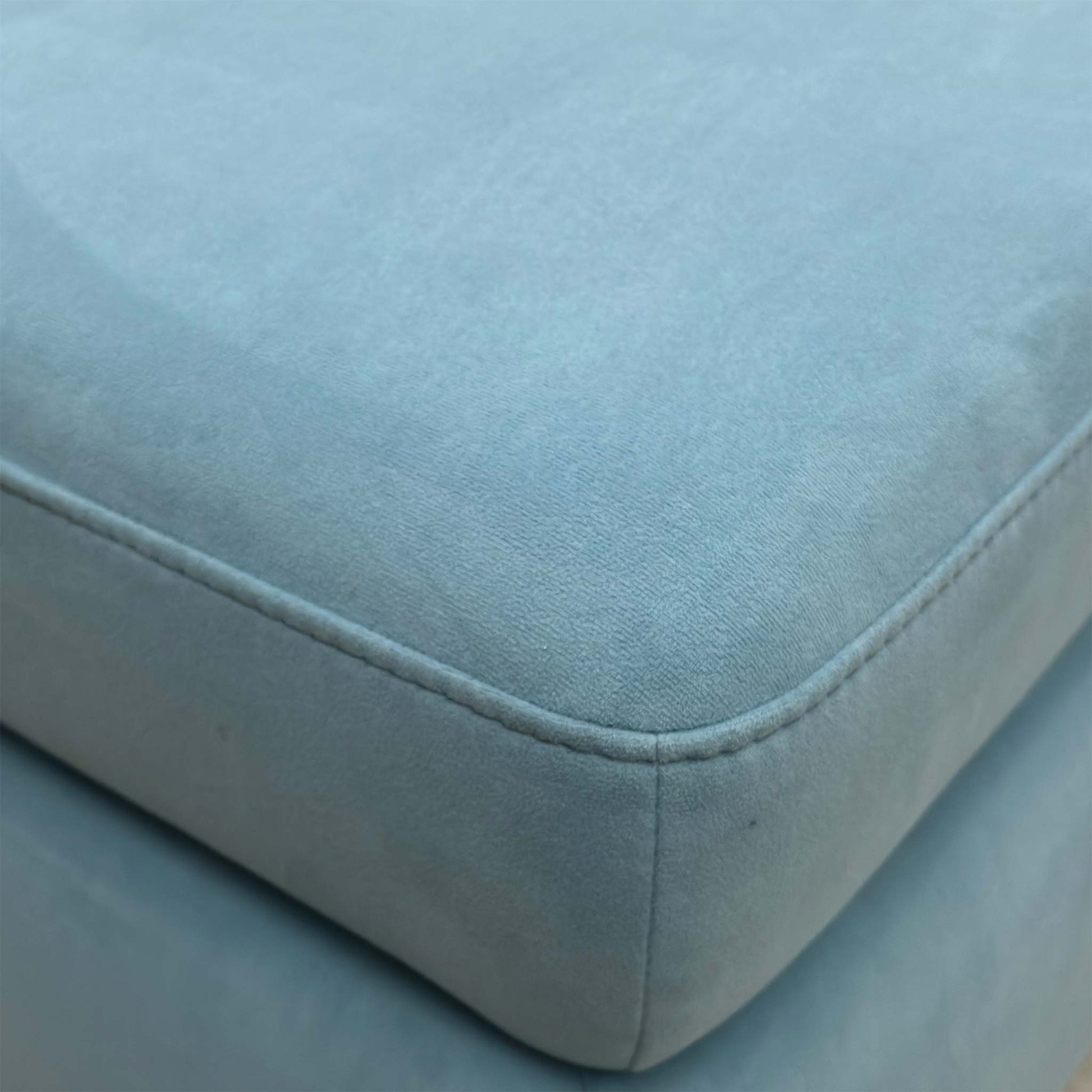 Close-up of the baby blue velvet upholstery, emphasizing the plush texture and the light, vibrant color tone.