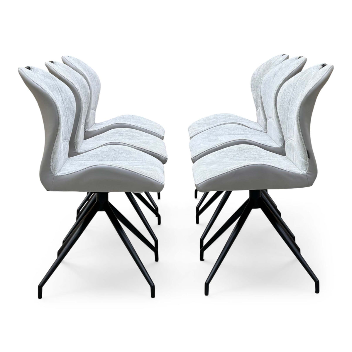 Side profile of the six stone grey fabric swivel dining chairs from the Raul set, in two rows of three