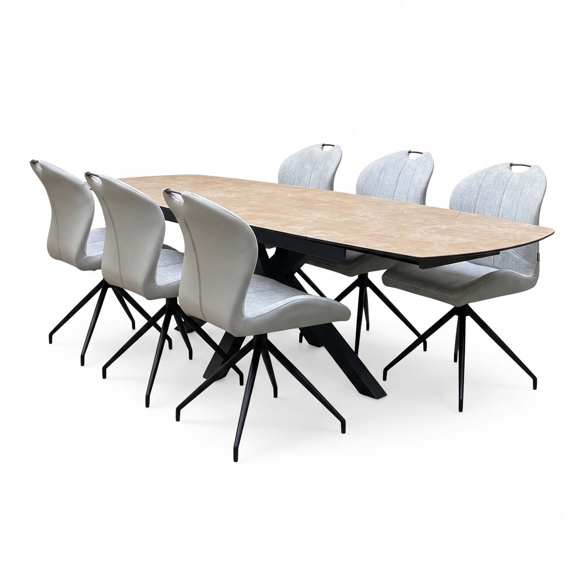 Raul extended ceramic dining table and six swivel chairs seen from the right end, showing the black star base