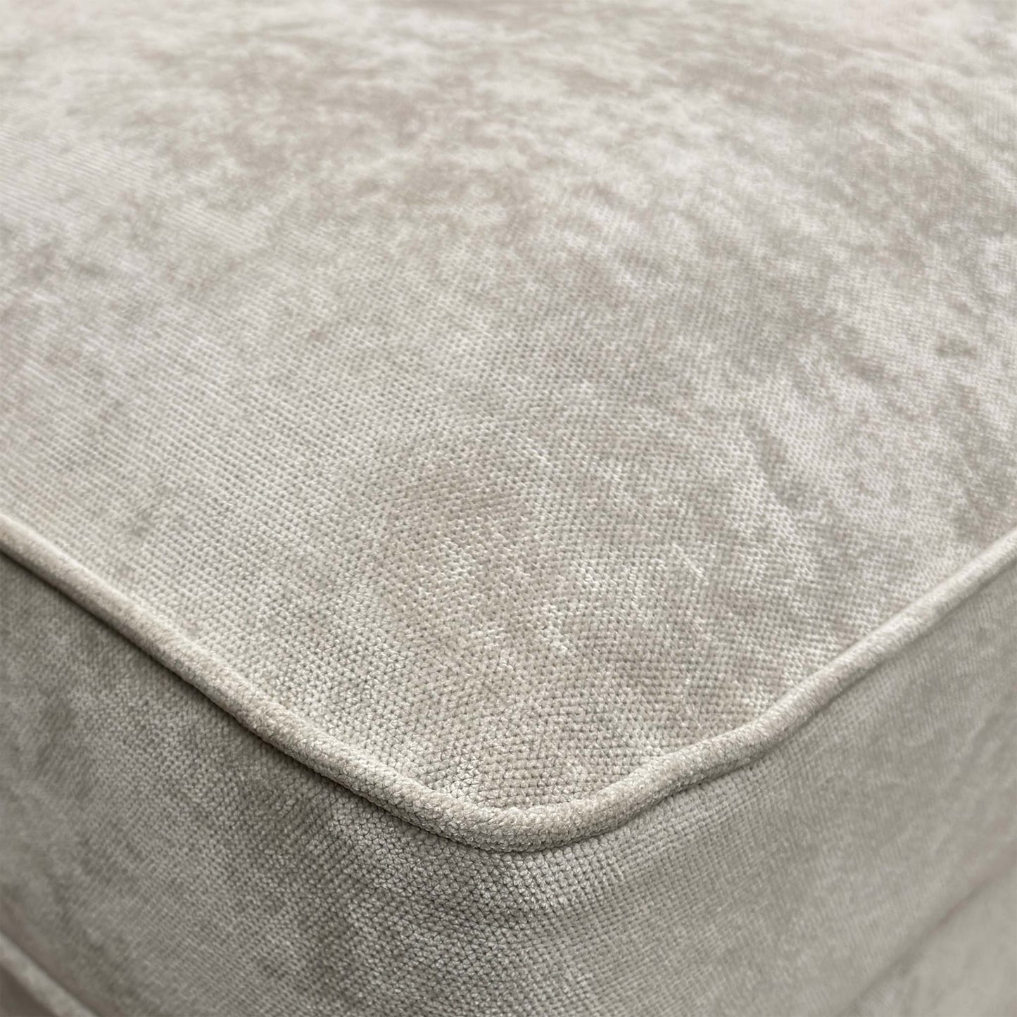 Close-up of the silver fabric, emphasizing the soft texture, subtle sheen, and the precise button-tufting detail.