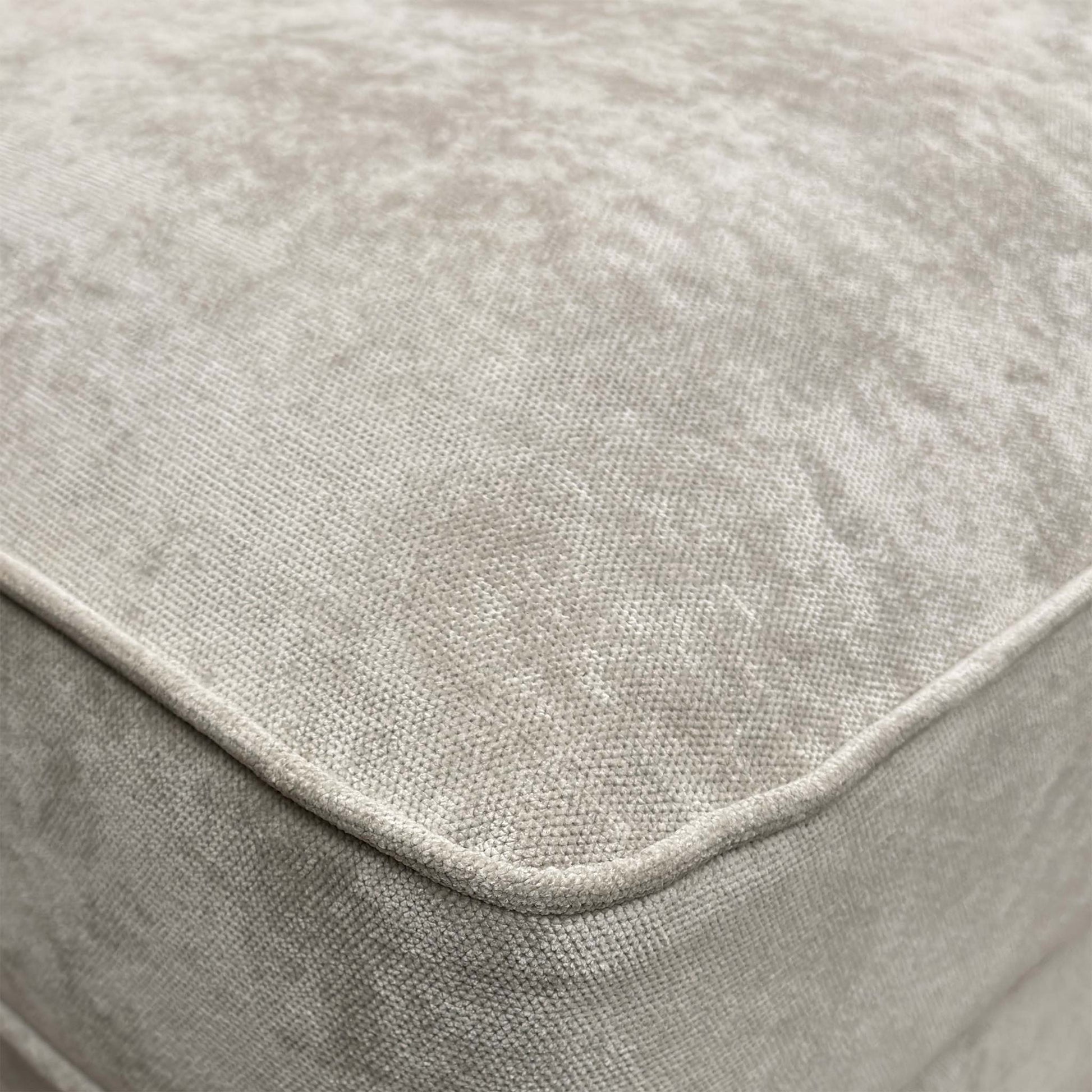 Close-up of the silver fabric, emphasizing the soft texture, subtle sheen, and the precise button-tufting detail.