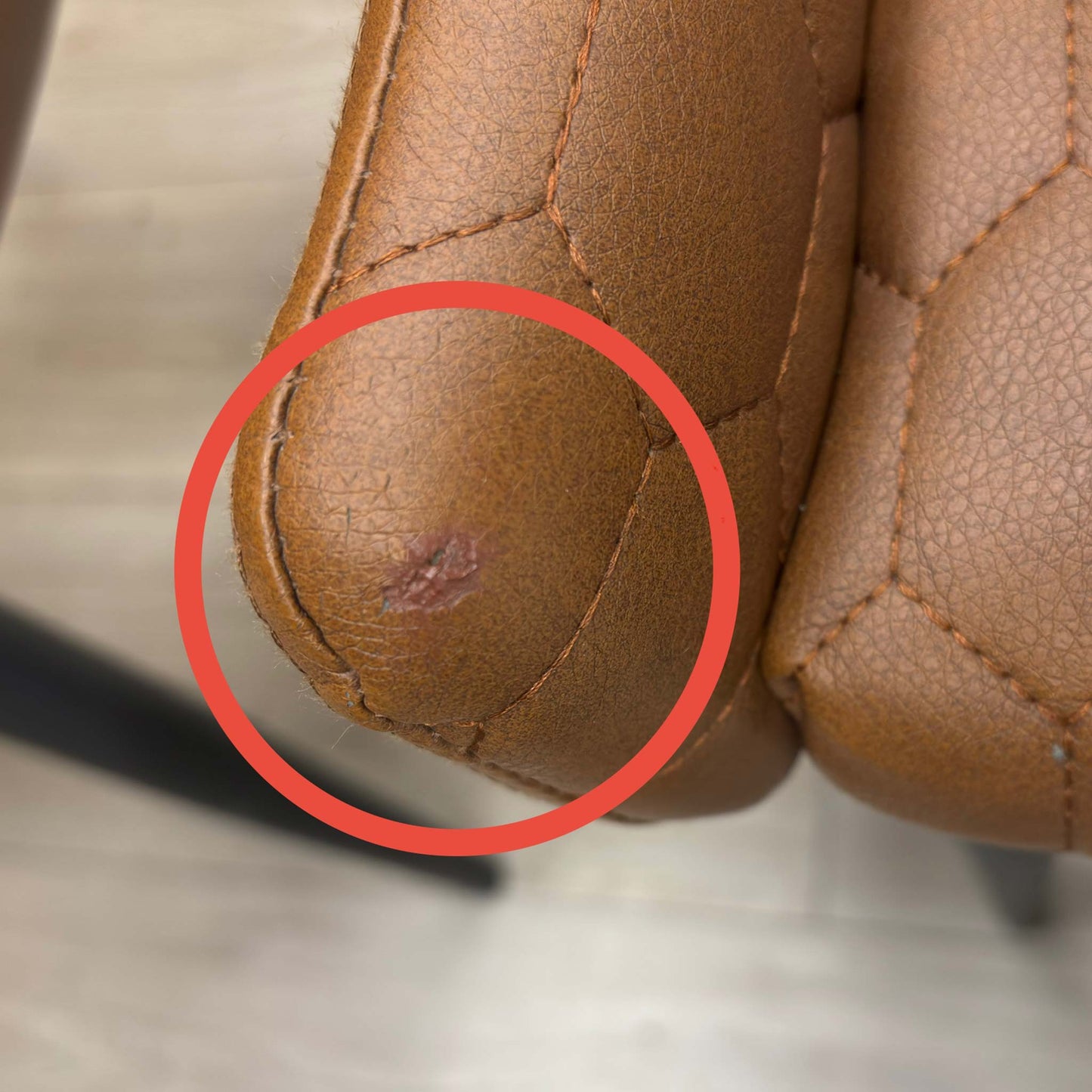 Rear view of the Osaka chair, showing the upholstery finish and a small scuff or surface mark on the back panel.