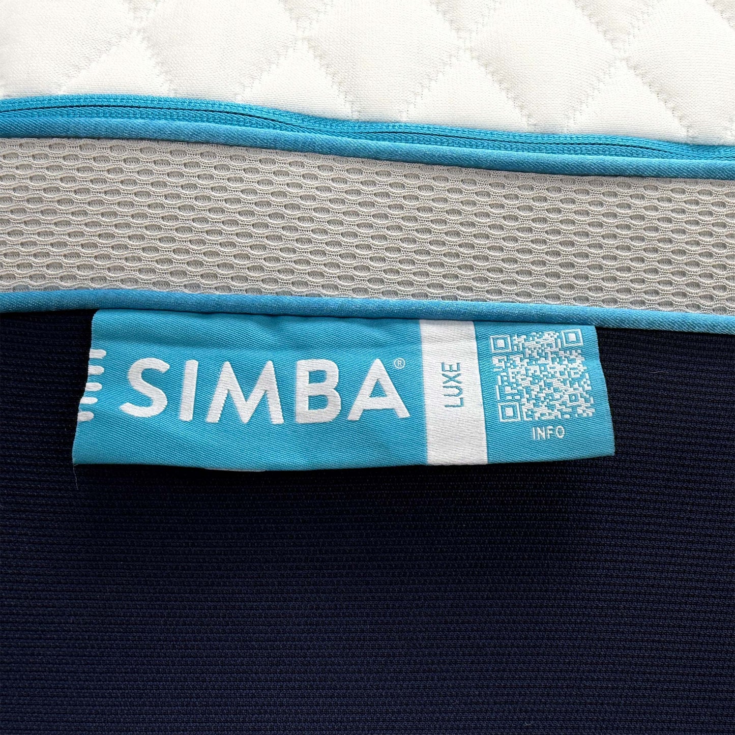 Close up shot of the mattress corner with the blue Simba branding and the heavy-duty handles designed for easier maneuvering of the king size model.