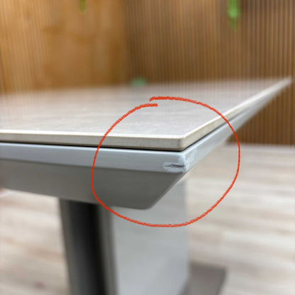 Another angle of the table's edge, documenting the specific condition of this outlet item.