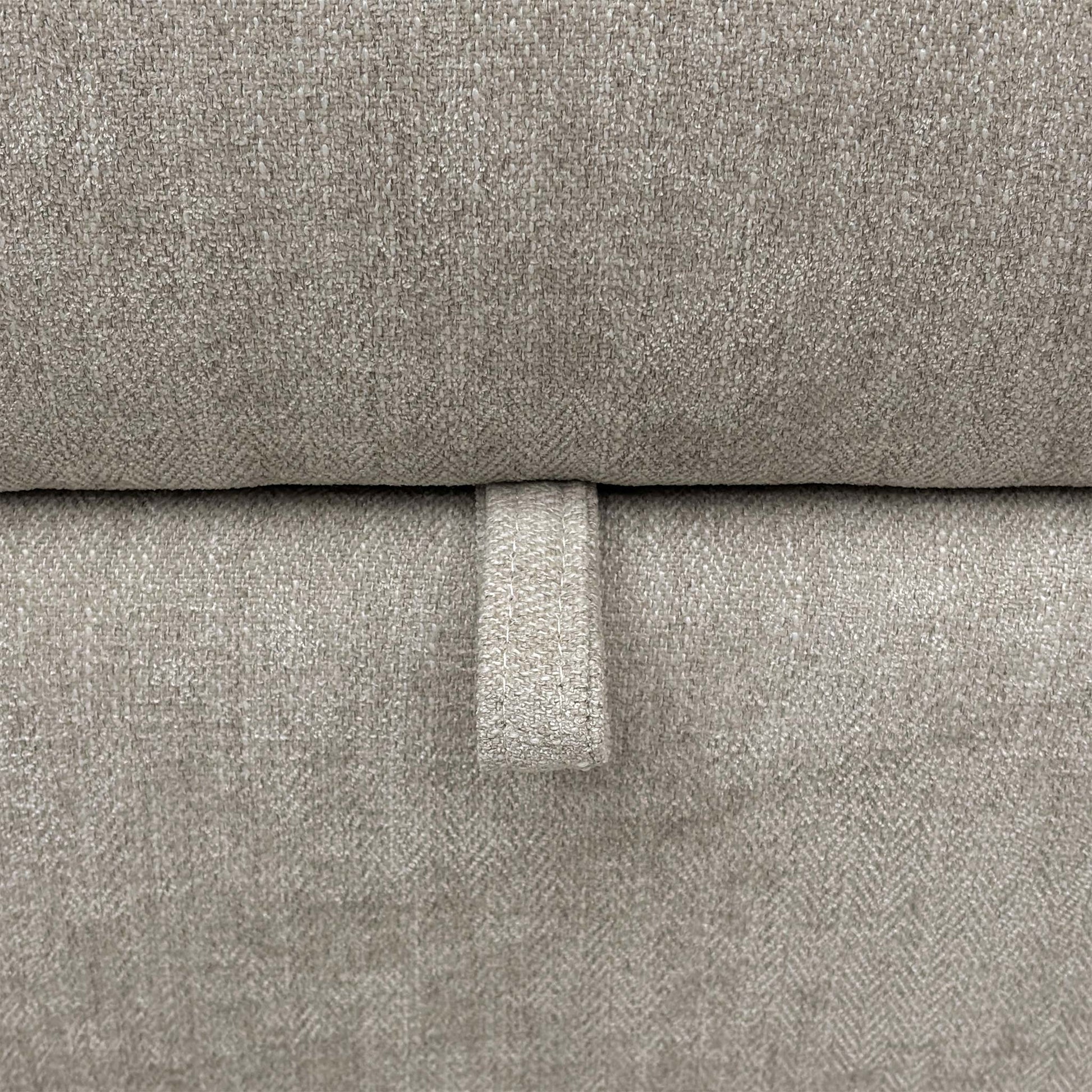 Close-up of the grey fabric upholstery, highlighting the durable weave texture, neutral tone, and quality stitched seams.