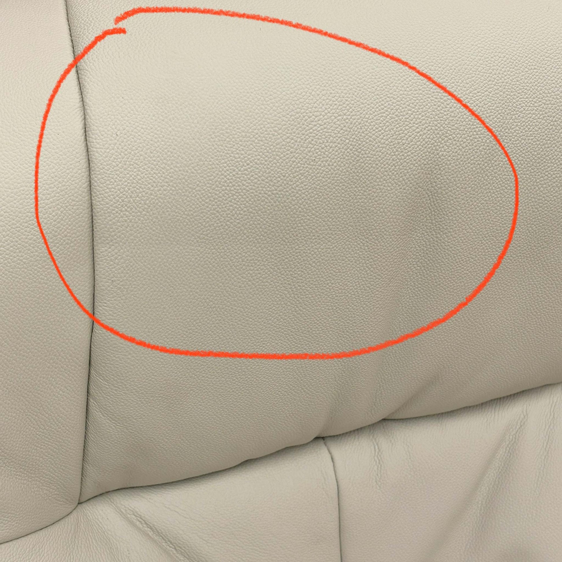 Close-up of the damage on Mushroom leather upholstery.