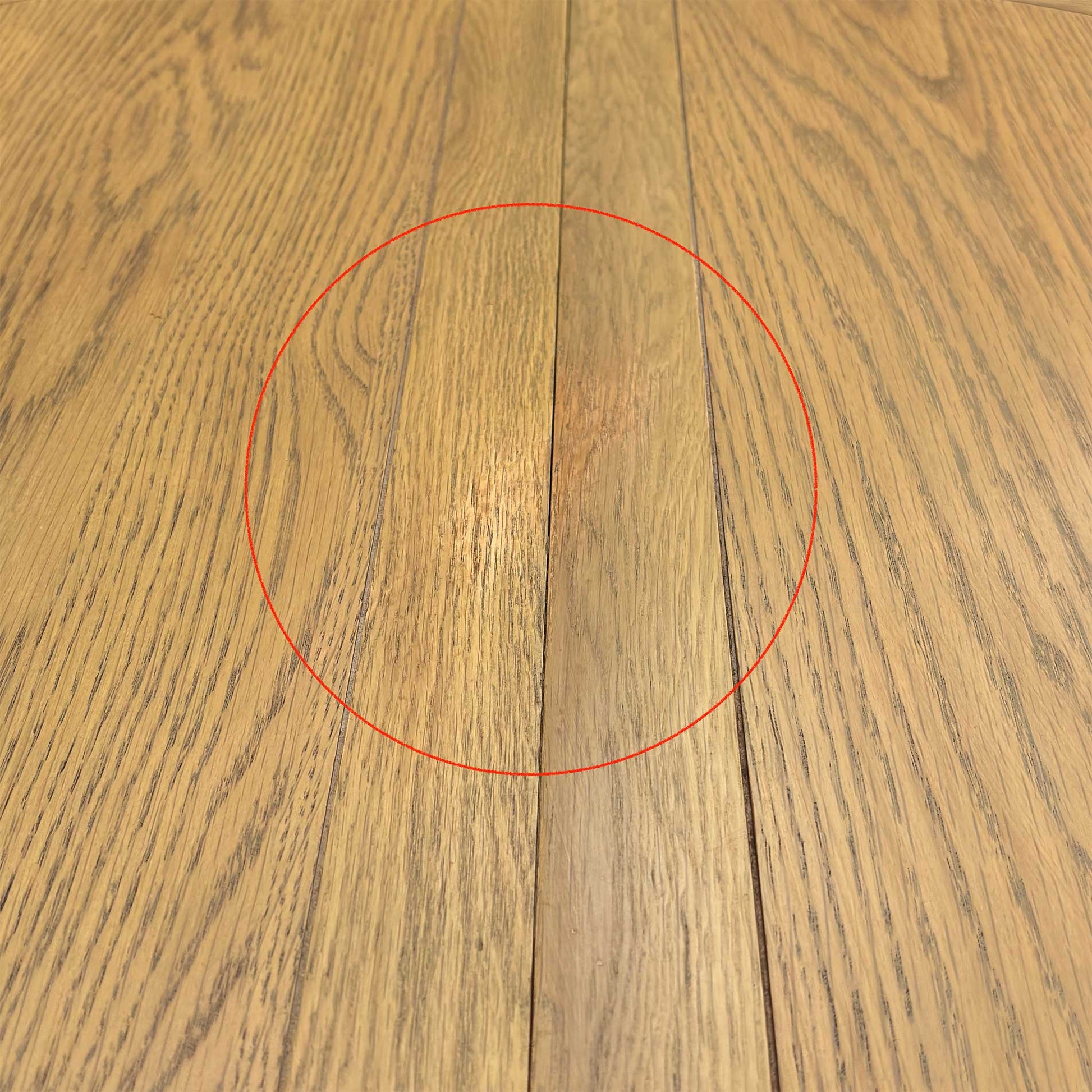 Detail shot of the thick, solid oak pedestal support and feet, showing the robust craftsmanship and architectural detail of the table's base.