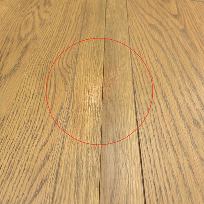 Detail shot of the thick, solid oak pedestal support and feet, showing the robust craftsmanship and architectural detail of the table's base.
