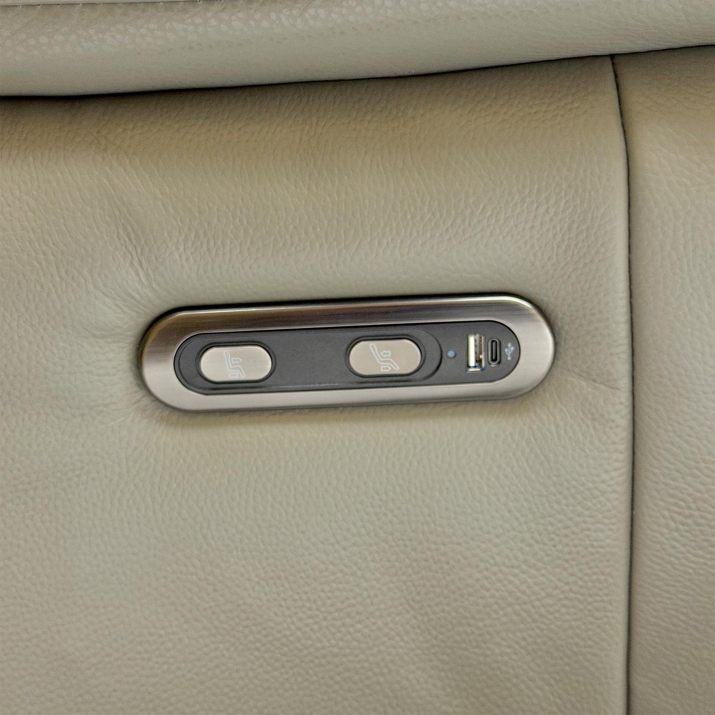Detail shot of the chrome-finished power control buttons on the side of the sofa, including the built-in USB charging port.