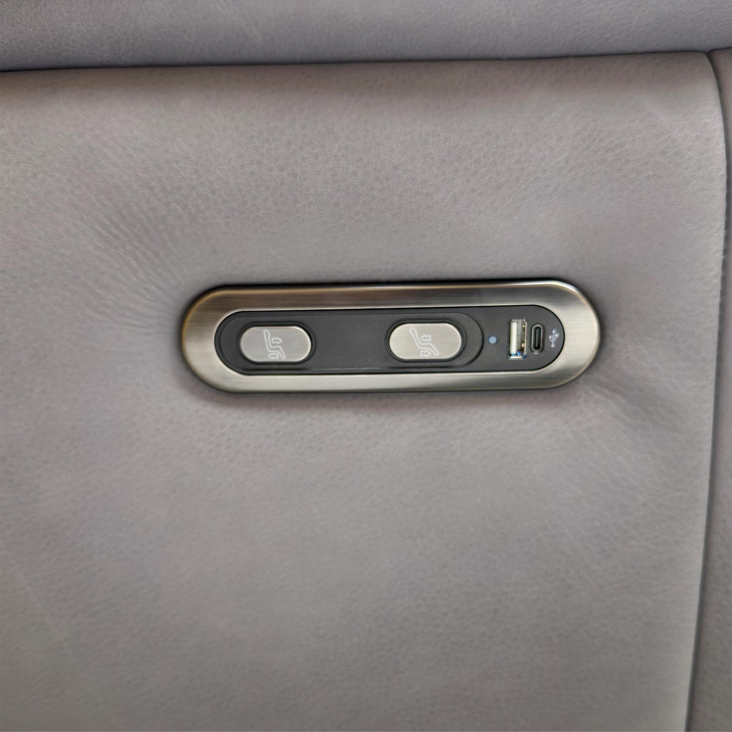 Close up shot of the side power control panel, showing the reclining buttons and the convenient built-in USB port for charging devices.