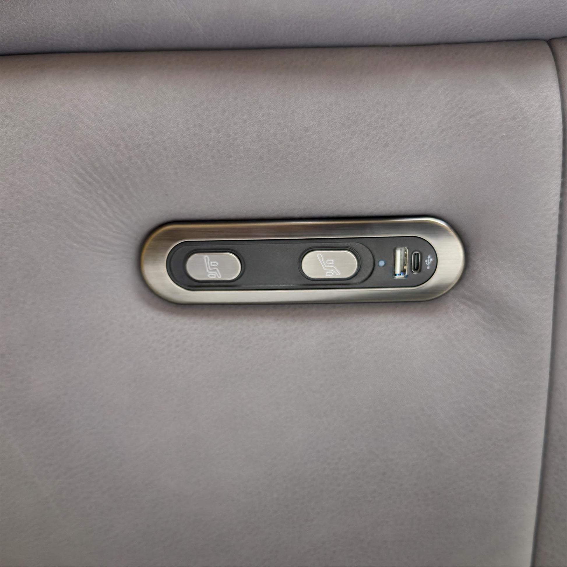 Close up shot of the side power control panel, showing the reclining buttons and the convenient built-in USB port for charging devices.