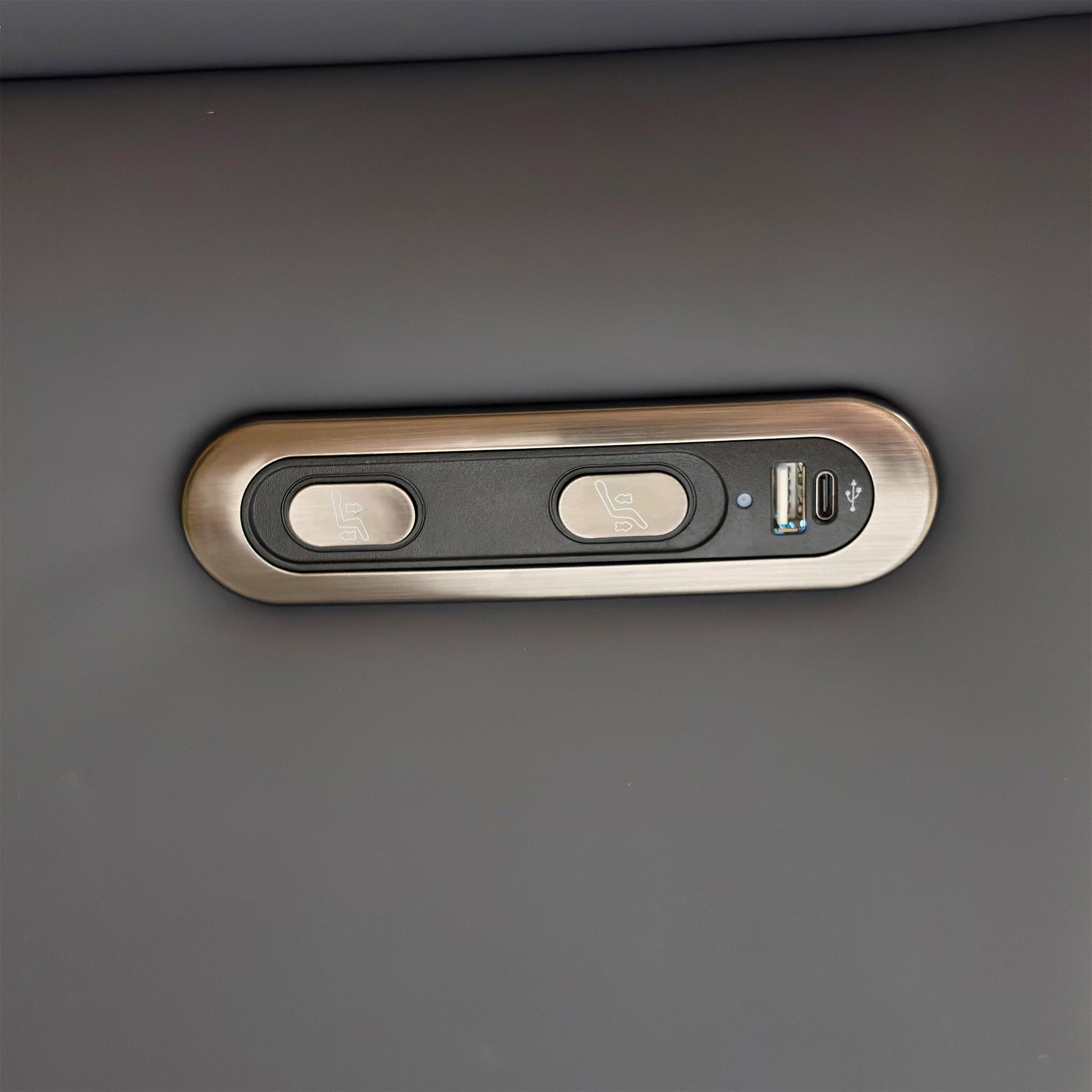 Detail shot of the power control buttons on the side of the armrest, showing the integrated USB charging port.
