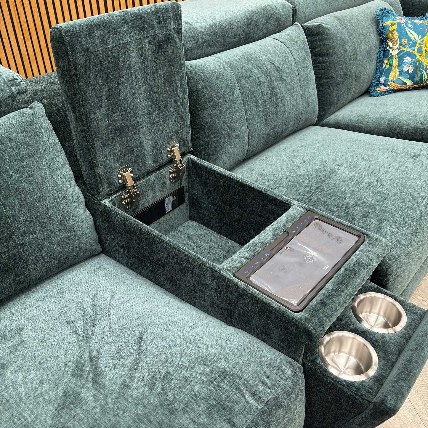 Detail shot of the central console, showing the stainless steel cup holders and the lift-up lid for the internal storage compartment.