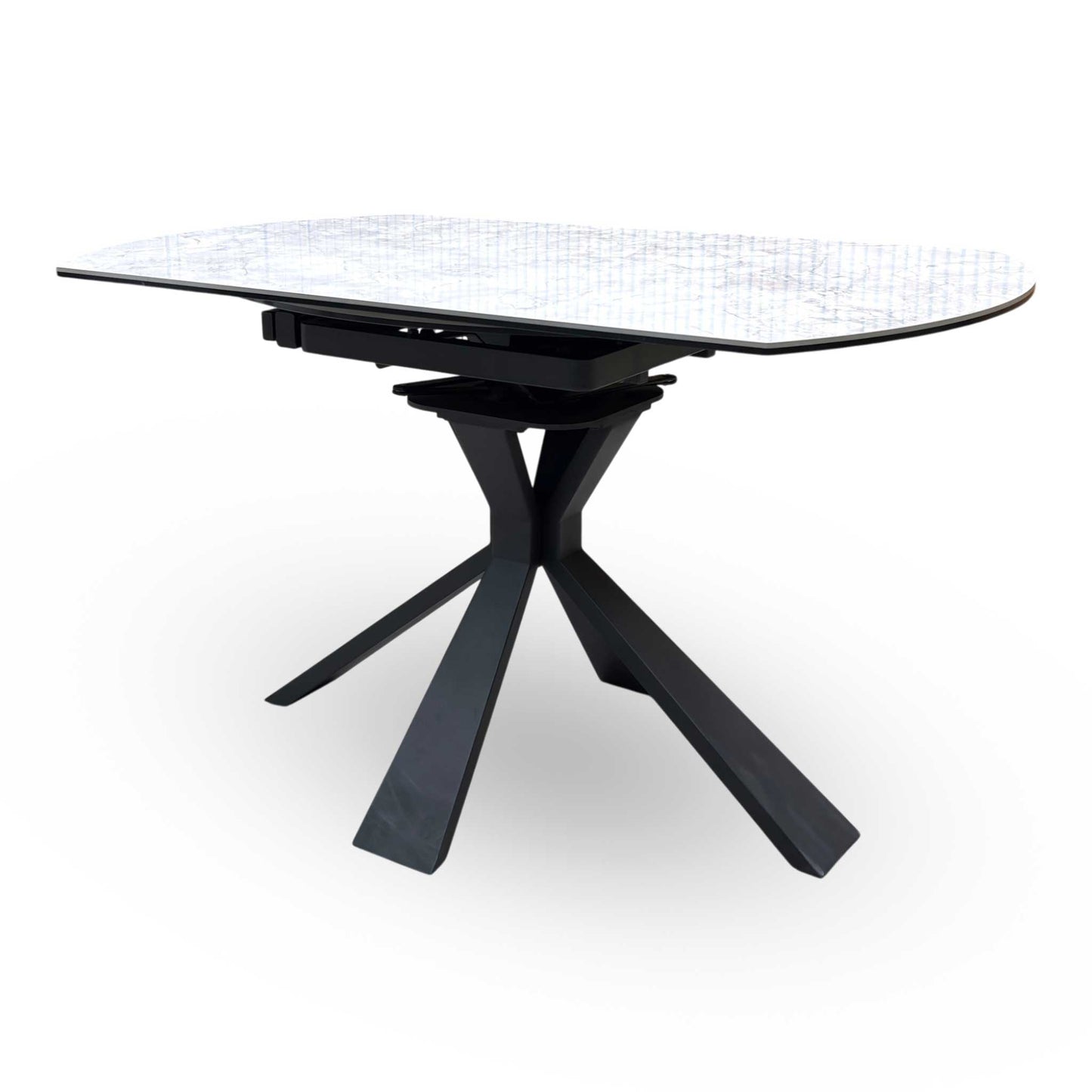 Side view of the Crete dining table in its compact round form, showcasing the durable textured stone finish and the architectural geometric leg design.