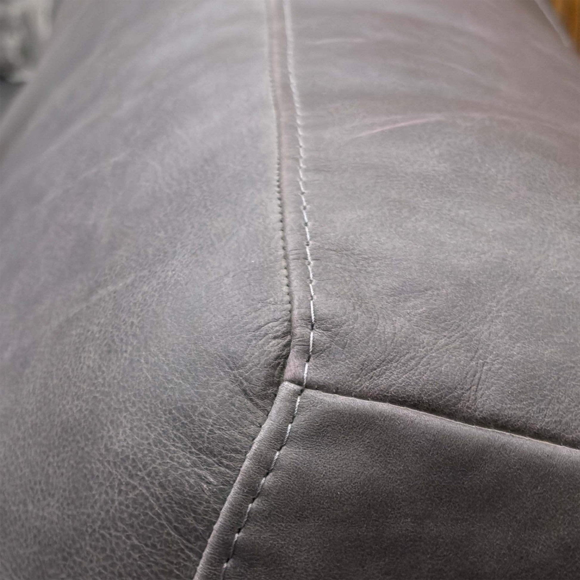 Close-up detail of the Grey Italian Leather upholstery, showing the natural grain, high-quality stitching, and soft texture of the premium hide.